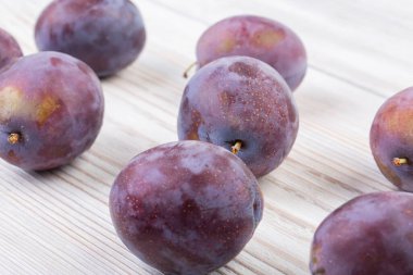 Tahta beyaz bir masada olgun erikler