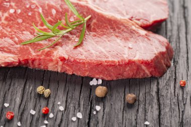 Ahşap arka planda iki taze mermer biftek.