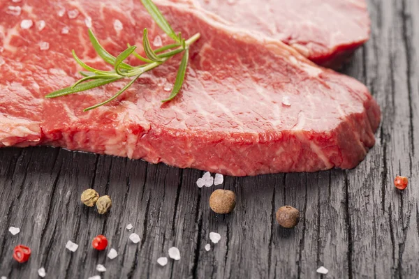 Ahşap arka planda iki taze mermer biftek.