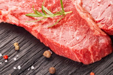 Ahşap arka planda iki taze mermer biftek.