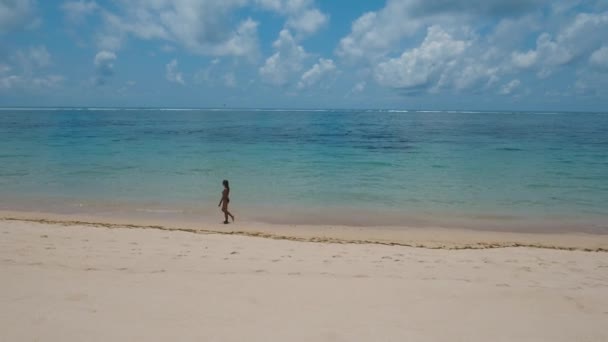 Kumsalda yürüyen bir kız. Bali, Endonezya. — Stok video