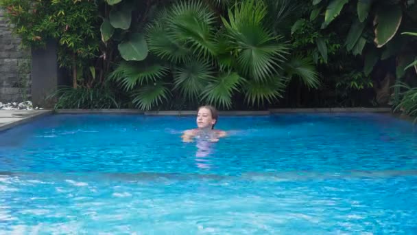 Chica está nadando en la piscina. — Vídeo de stock