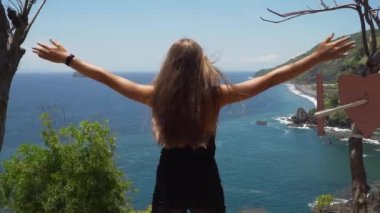 Uçurumun kenarında duran ve denize bakan bir kız. Bali, Endonezya