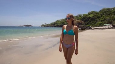 Kumsalda yürüyen bir kız. Bali, Endonezya.
