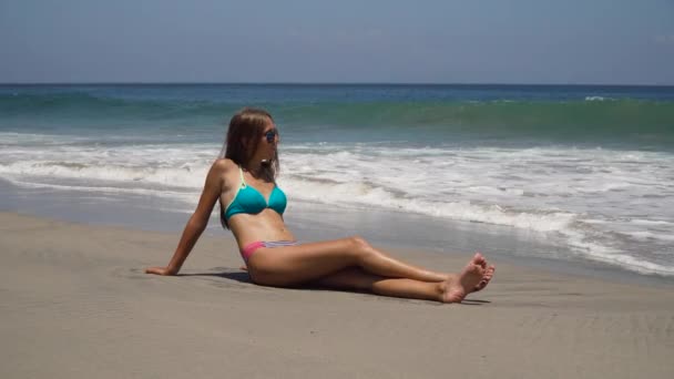 Güneş gözlüklü kız sahilde oturuyor.. — Stok video