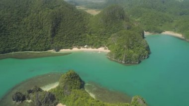 Havadan görünümü ile kum plaj ve turkuaz su mercan resifleri, Caramoan Adaları, Filipinler arasında mavi lagün Adaları. Tropikal ormanı ile kaplı dağları.
