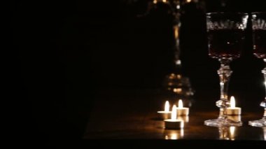 Şarap, gözlük ve yanan mumlar.