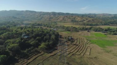 Güç dikmesi ve dağ cordillera ile geçen yüksek gerilim hatları. Filipinler, Luzon. Havadan görünümü yüksek gerilim metal direk, kule. Elektrik güç iletim hatları üzerinden ağaçlar.