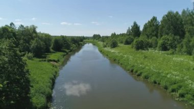 Nehir ve ağaçlarla kaplı manzara.