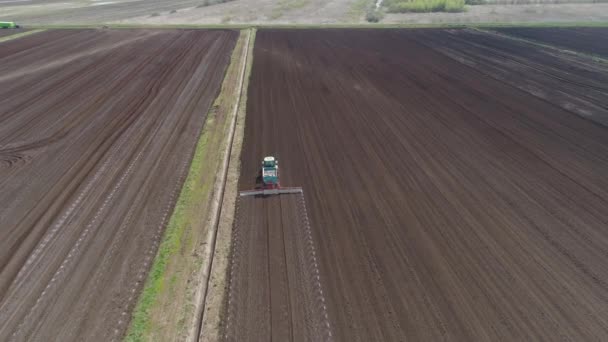 Trekker op landbouwgronden is gecultiveerd met meststoffen. — Stockvideo
