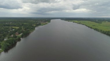 Nehir ve ağaçlarla kaplı manzara.