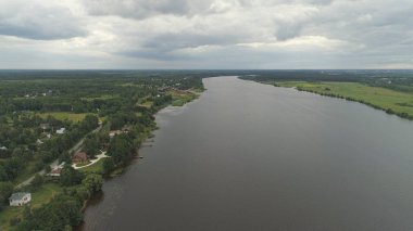 Nehir ve ağaçlarla kaplı manzara.