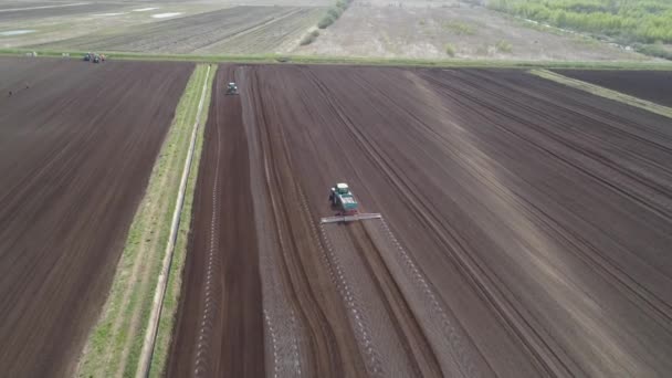 Traktor på jordbruksmark odlas med gödningsmedel. — Stockvideo