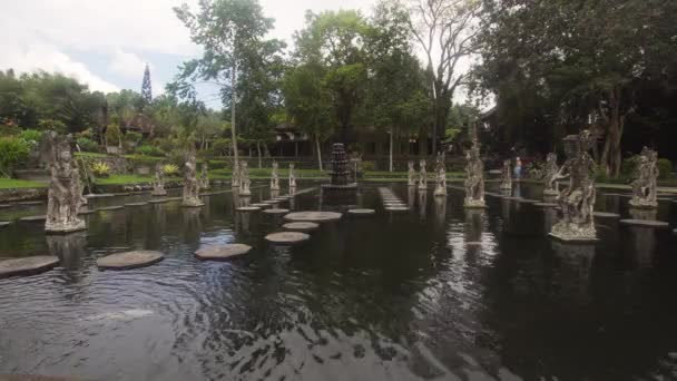 印度教巴厘岛水宫殿 Tirta Gangga 与神的雕像 喷泉在巴厘岛 印度尼西亚 Tirta Gangga 前御水宫殿是一个迷宫的水池和喷泉包围的郁郁葱葱 — 图库视频影像