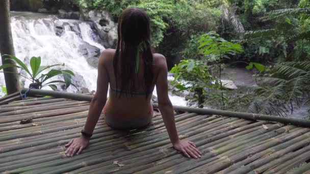 Девушка смотрит на красивый водопад . — стоковое видео