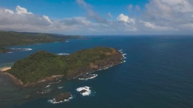 Tropik ada, kayalar ve dalgalar deniz manzarası. Catanduanes, Filipinler.