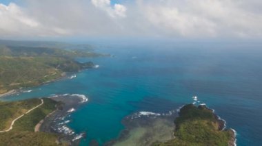 Tropik ada, kayalar ve dalgalar deniz manzarası. Catanduanes, Filipinler.