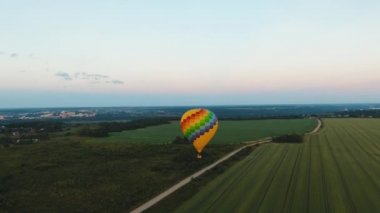 Havadan görünümü sıcak hava balonu güzel gökyüzü ve günbatımı kırsal bir alanda üzerinde gökyüzünde. Aerostat şehir dışında uçar. Havadan görüntüleri, 4k