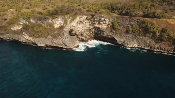 Penida 悬崖上有波浪撞击岩石海岸 鸟瞰岩石海岸和海浪和岩石悬崖的海洋 旅游理念 空中素材 — 图库视频影像