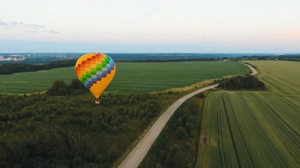 Montgolfière dans le ciel au-dessus d'un champ . — Photo