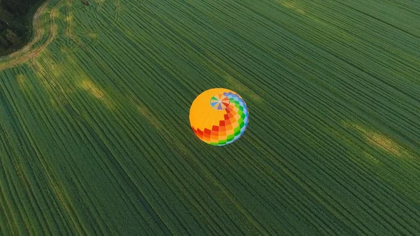 Luchtballon in de lucht over een veld. — Stockfoto