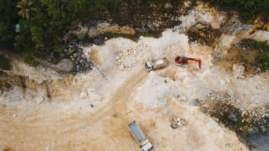 Ekskavatör ocağında kamyon yükler. Filipinler, Siargao.