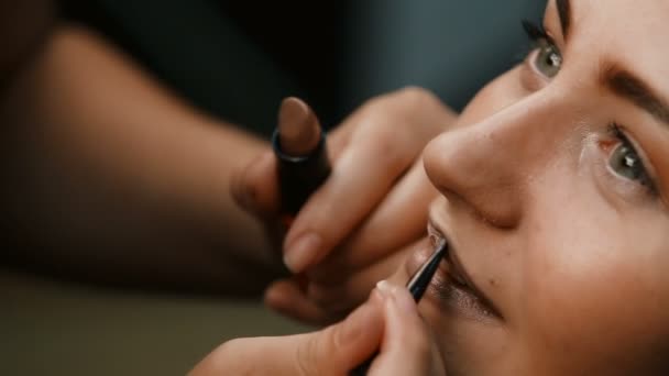 Tvoří umělec dělá profesionální make-up mladé ženy — Stock video