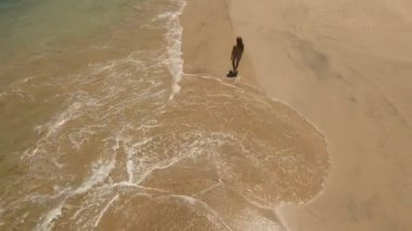 Kumsalda yürüyen bir kız. Bali, Endonezya.