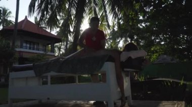 Asya 'daki bir kıza masaj yapan bir kadın. Bali, Endonezya.