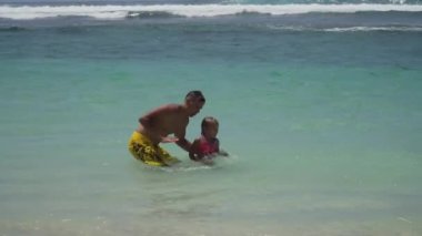 Baba ve kızı deniz üzerinde oynamak.