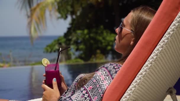 Chica con una copa de cóctel cerca de la piscina. — Vídeos de Stock