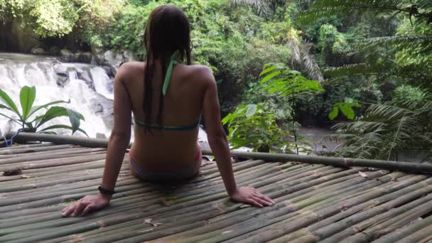 Meisje kijkt naar een prachtige waterval. — Stockvideo