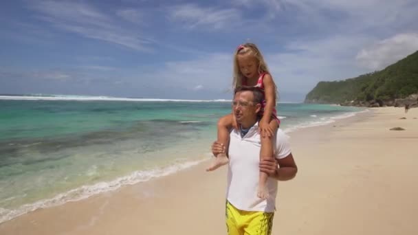 Far med dotter med barn på stranden. — Stockvideo