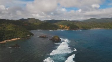 Tropik ada, kayalar ve dalgalar deniz manzarası. Catanduanes, Filipinler.