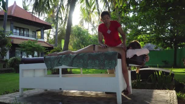 Een vrouw die een meisje masseert in Azië. Bali, Indonesië. — Stockvideo