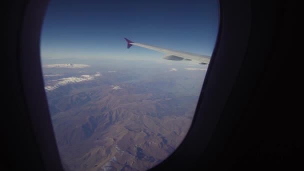 Blick aus dem Flugzeugfenster auf die Berge. — Stockvideo
