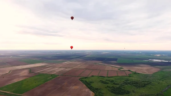Des montgolfières dans le ciel au-dessus d'un champ . — Photo