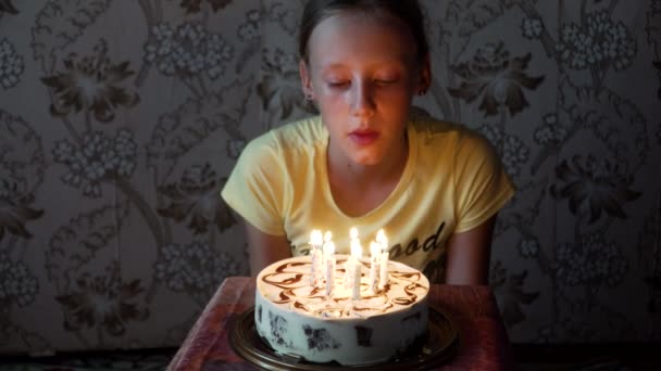 Молода дівчина вибухає свічки на день народження — стокове відео