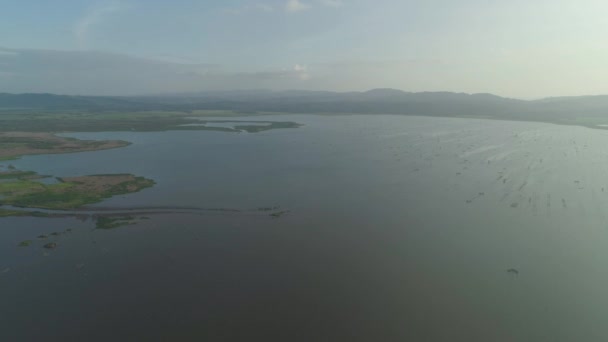 Paisaje con un lago, tierras agrícolas y montañas . — Vídeos de Stock