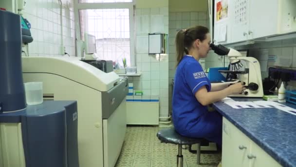 Femme médecin regarde dans un microscope. — Video
