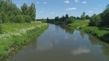 Nehir ve ağaçlarla kaplı manzara.