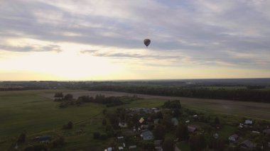Sıcak hava balonu bir alanın üzerinde gökyüzünde.