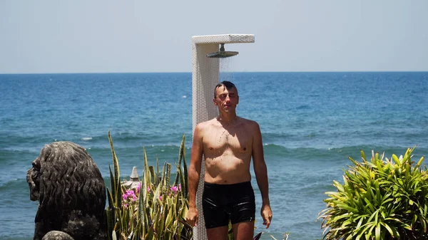 Hombre y ducha en la playa — Foto de Stock