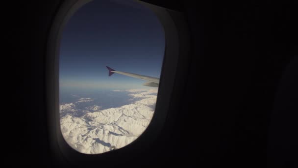 Uitzicht vanuit vliegtuig raam op bergen. — Stockvideo