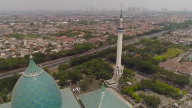 Camili Surabaya şehri, Al Akbar, karayolu, gökdelenler, binalar ve evler. Endonezya 'nın Surabaya kentindeki Al Akbar camii. Java Endonezya adasında minareleri olan güzel bir cami.
