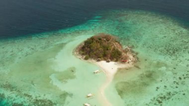 Beyaz kumlu sahili olan küçük torpik bir ada..