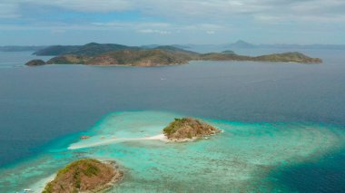 Beyaz kumlu sahili olan küçük torpik bir ada..