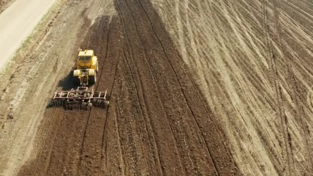 Mezőgazdasági területen tárcsás boronával felszerelt traktor — Stock videók