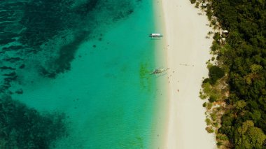 Tropik plaj ve turkuaz göl suyu.