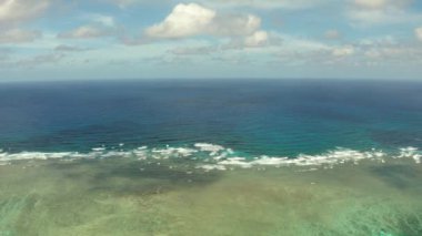 Deniz manzarası, mavi deniz, bulutlu ve adalı gökyüzü.